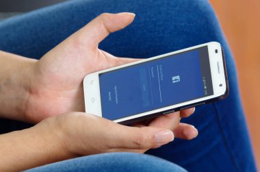 Quito, Ekvator - 09 Mayıs 2017: Kadın el giriş ekranı facebook simgeleri Apple iphone üzerinde modern cep telefonu ile. Dünyanın en büyük ve en popüler sosyal ağ sitesi