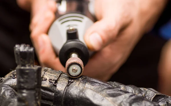 Close-up van een selectieve aandacht van een hardworker man met een polijstmachine via een metalen standbeeld — Stockfoto