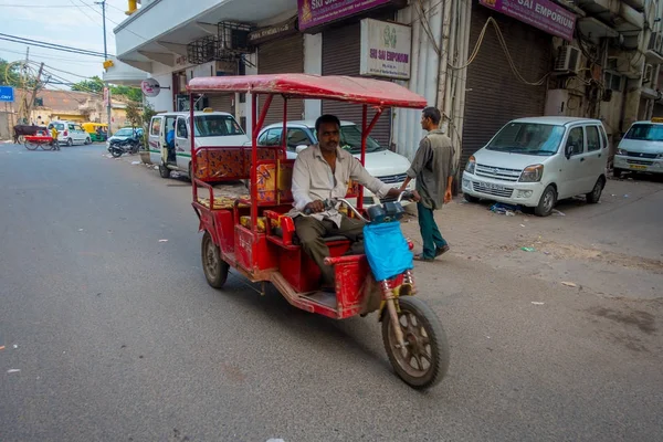 DELHI, INDIA - 25 DE SEPTIEMBRE DE 2017: Personas no identificadas dentro de una motocicleta roja en la avenida de Paharganj, Delhi. Delhi es la segunda ciudad más poblada de la India después de Mumbai — Foto de Stock