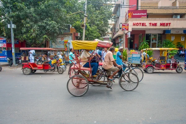 Delhi, Indie - 25 września 2017: Niezidentyfikowanych osób wewnątrz czerwony riksze i auto riksze w avenue w dzielnicy Paharganj, Delhi. Delhi jest 2 najbardziej zaludnione miasto w Indiach po Bombaju — Zdjęcie stockowe