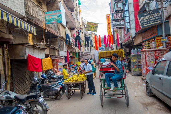 Delhi, Índia - 25 de setembro de 2017: Pessoas não identificadas andando em uma rua movimentada, com um jovem em um carrinho com bananas em Paharganj Delhi com compradores muçulmanos — Fotografia de Stock