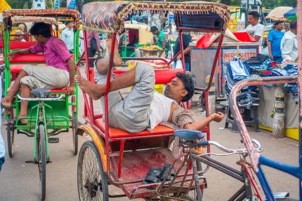 Delhi, Indie - 25 września 2017: Niezidentyfikowany mężczyzna odpoczynek nad jego czerwony riksze na ulicach w dzielnicy Paharganj, Delhii. Delhi jest 2 najbardziej zaludnione miasto w Indiach po Bombaju — Zdjęcie stockowe