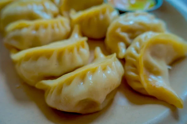 Close up de Momo cozido no vapor servido em um prato branco. Um alimento nepalês popular que também é comum em Chiana, Butão, Tibete e Índia — Fotografia de Stock