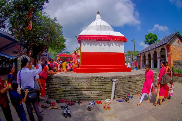 KATHMANDU, NEPAL - SETTEMBRE 04, 2017: Persone non identificate che donano oblazioni a una struttura bianca e rossa lapidata statue all'aperto vicino al tempio di Bindabasini, è di grande importanza religiosa per — Foto Stock