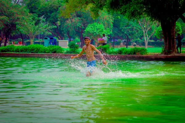 델리, 인도-9 월 16 일, 2017: 미확인된 행복 인도 소년 연못, 델리에서 녹색 물에서 실행 — 스톡 사진