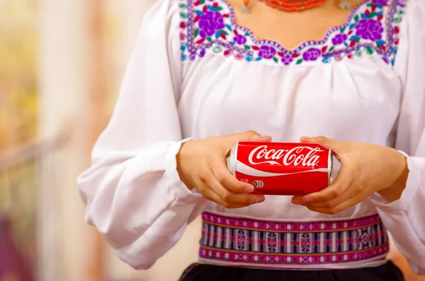 Quito, Ecuador - 06 maggio 2017: Giovane donna che indossa abiti indigeni e indica da lei una coca — Foto Stock