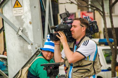 Quito, Ekvator - 11 Ekim 2017: tüm röportaj Ekvador ve Arjantin, hayranları ile çığlık ve onların takım destekleyen atlama kişilik bir kalabalık ile kurtarma camarographer, kapat