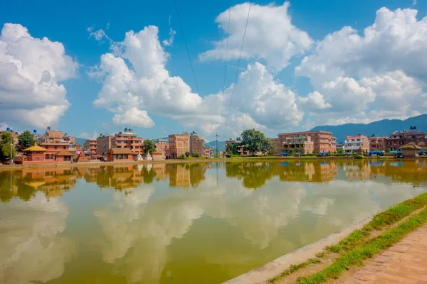 BHAKTAPUR, NEPAL - 04 DE NOVIEMBRE DE 2017: Primer plano de la borrosa escena urbana tradicional con un estanque artificial de agua amarilla en la ciudad de Bhaktapur, Nepal —  Fotos de Stock