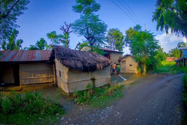 POKHARA, NEPAL 10 DE OCTUBRE DE 2017: Primer plano de edificios antiguos cerca de una calle rocosa en una ciudad de Sauraha, Nepal —  Fotos de Stock