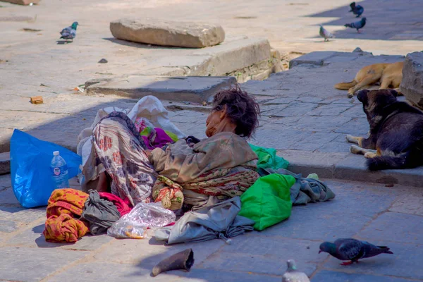 KATHMANDU, NEPAL OUTUBRO 15, 2017: Sem-teto nepalês não identificado deitado no chão das ruas, vestindo roupas sujas ao ar livre em uma praça Durbar perto de templos hindus antigos em Katmandu, Nepal — Fotografia de Stock