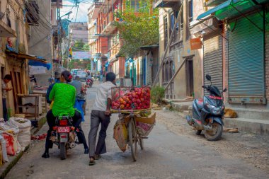 Katmandu, Nepal 15 Ekim 2017: Bir bisiklet bir metal sepet ve motorcicles tarihi merkezi Katmandu, Nepal sokakta insanlar içinde bazı elma meyve ile tanımlanamayan erkekte