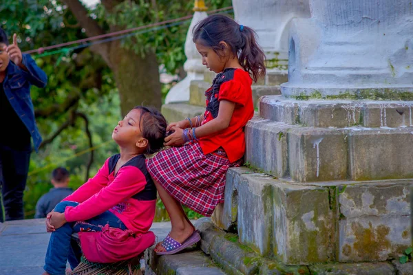 KATHMANDU, NEPAL 15 OCTOBRE 2017 : Enfants non identifiés assis à l'extérieur près de Swayambhu, une ancienne architecture religieuse au sommet d'une colline à l'ouest de la ville de Katmandou. Il est également connu sous le nom de Temple des Singes — Photo