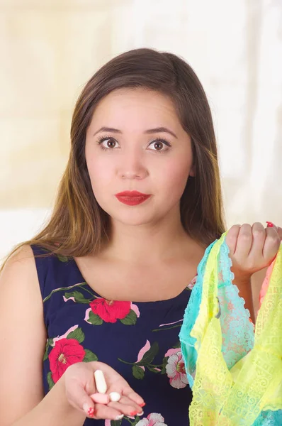 Close up of a young woman, holding an assorted colorful underwears and a soft gelatin vaginal tablet or suppository, treatment of diseases of the reproductive organs of women and prevention of womens — Stock Photo, Image