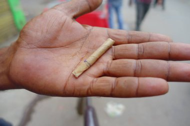 Delhi, Hindistan - 25 Eylül 2017: bir adamın sigarayla yaprak sarılı el yapımı, Paharganj yeni delhi Hindistan sokaklarında el kapat