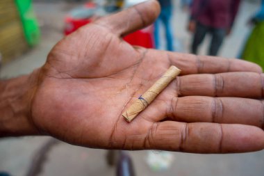 Delhi, Hindistan - 25 Eylül 2017: bir adamın sigarayla yaprak sarılı el yapımı, Paharganj yeni delhi Hindistan sokaklarında el kapat