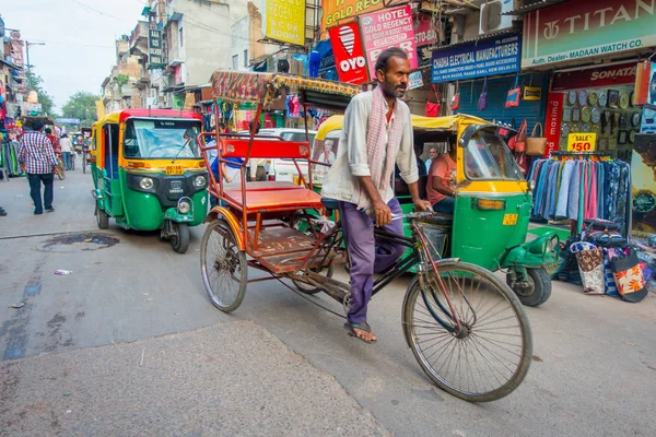DELHI, INDIA - 25 SETTEMBRE 2017: Uomo non identificato in bicicletta accanto a un Rickshaws parcheggiato nelle strade e un auto-risciò a Paharganj, Delhi Delhi è la seconda città più popolosa in India dopo Mumbai — Foto Stock