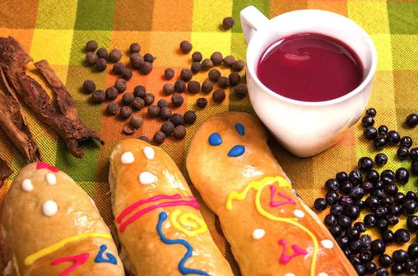 Gros plan sur un plat équatorien traditionnel, la colada morada et trois guaguas de pan sur un tissu coloré — Photo