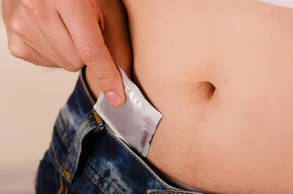 Close-up van de mens een condoom binnenkant van zijn prive-onderdelen, een teken van een veiligheid geslacht verbergen — Stockfoto