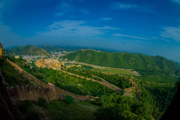 Hermoso paisaje de Amber Fort con árboles verdes, montañas y pequeñas casas cerca de Jaipur en Rajasthan, India. Amber Fort es la principal atracción turística en la zona de Jaipur — Foto de Stock