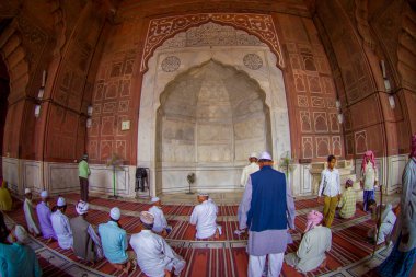 Delhi, Hindistan - 27 Eylül 2017: Tanımlanamayan grup yerde oturan ve Delhi, Hindistan, balık göz etkisi tapınakta içindeki Jama Mescidi camide dua adam