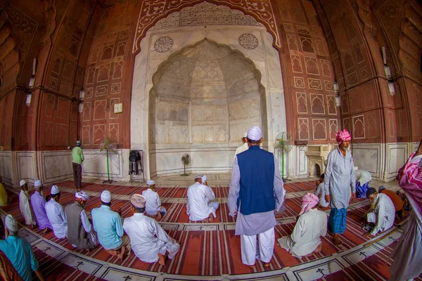 Dillí, Indie - 27 září 2017: Neznámá skupina lidí sedí na podlaze a modlí v mešitě Jama Masjid uvnitř chrámu v Dillí, Indie, rybí oko efekt — Stock fotografie