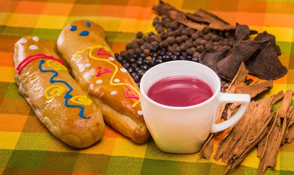 Detailní záběr tradiční ekvádorské misky, colada morada a dva guaguas de pan přes barevné tkaniny — Stock fotografie