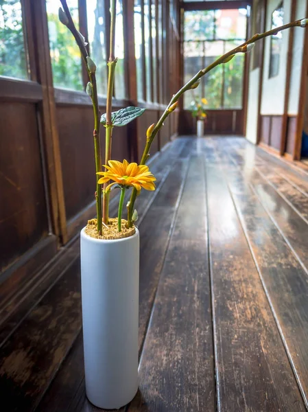Nahaufnahme einer Blumenvase mit einer gelben Blume in Innenansicht der Halle mit Holzboden, in Kyoto, Japan — Stockfoto