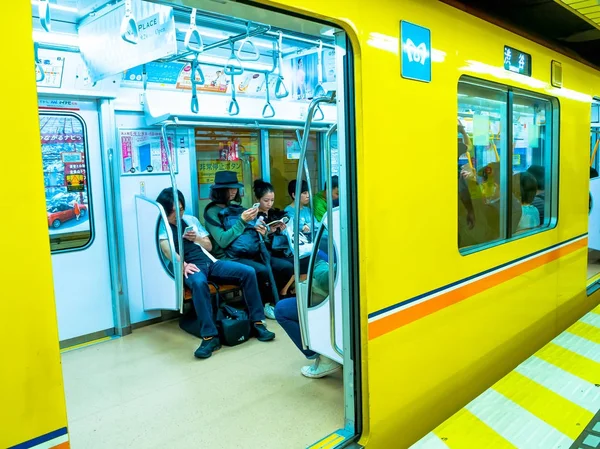 Tokyo, Japan - 2 Jan 2016. Mensen zitten in een Yamanote trein in Tokio, Japan. Het spoorwegsysteem in Japan heeft een hoge reputatie voor stiptheid en veiligheid — Stockfoto