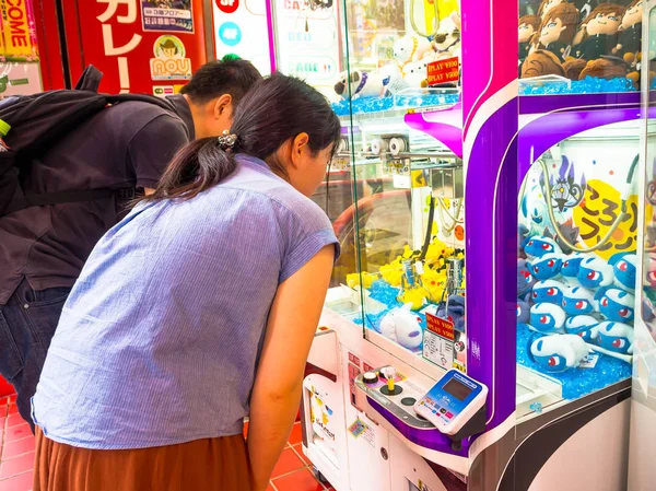 東京都 6 月 28-2017: 不明の人が東京でグッズ コイン機械に分類されたハロー キティ人形を探して — ストック写真