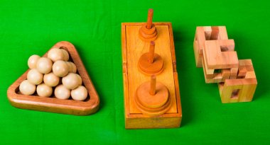 Çeşitli ahşap zeka oyunları veya yeşil zemin üzerine tahta bulmacalar