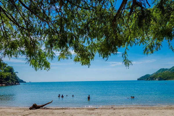 Buiten uitzicht op Taganga, de Caraïbische kust met sommige toeristen genieten van de zonnige dag in Colombia — Stockfoto