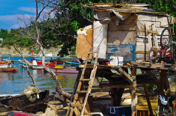 SANTA MARTA, COLOMBIA - 10 DE OCTUBRE DE 2017: Vista al aire libre de muchos barcos en el agua y una vieja cabaña de madera en una playa caribeña. Taganga, Colombia — Foto de Stock