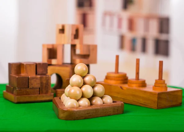 Assorted wooden brain teaser or wooden puzzles on green table in a blurred background