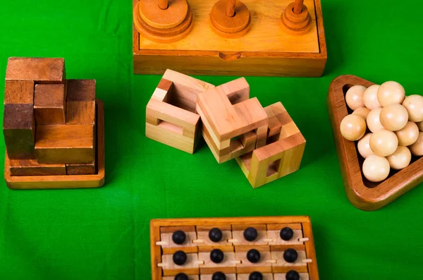 Assortiment de casse-tête en bois ou puzzles en bois sur fond vert — Photo