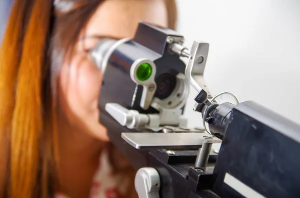 Mujer no identificada comprueba la visión por equipos modernos, examen de los ojos en óptica, en un fondo borroso — Foto de Stock