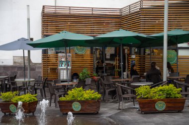 Quito, Ekvator Kasım, 28, 2017: Yeşil Dev şemsiyeleri ve sandalyeler ile bir restoran güzel açık manzarasına Quito Andes Kuzey Ekvator eski şehrin tarihi merkezine bulunan