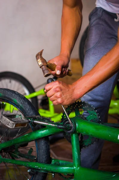 Close up de um homem trabalhando com um martelo sobre o pedal de bicicleta em uma oficina no processo de reparação — Fotografia de Stock