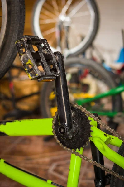 गोंधळलेल्या पार्श्वभूमीवर कार्यशाळेत यांत्रिकद्वारे निश्चित सायकल पेडल बंद करा — स्टॉक फोटो, इमेज