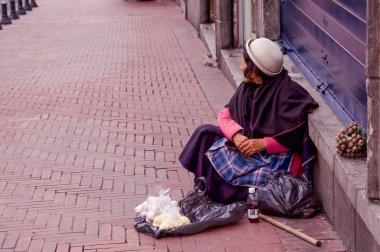 Quito, Ekvator Kasım, 28, 2017: Sarımsak tarihi itibariyle plastik torbalar içinde satan kaldırıma kimliği belirsiz bir kadın Merkezi eski kasaba Quito Kuzey Ekvator