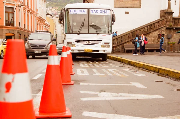 Quito, ecuador 28. November 2017: Nahaufnahme verschwommener orangefarbener Zapfen mit einem Bus und Menschen im Hintergrund im historischen Zentrum, öffentliche Verkehrsmittel des altstadtquito im Norden Ecuadors — Stockfoto