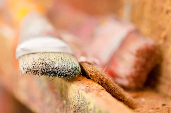 Close up of detail paint brushes over a color palette in a studio, in a blurred background — Stock Photo, Image