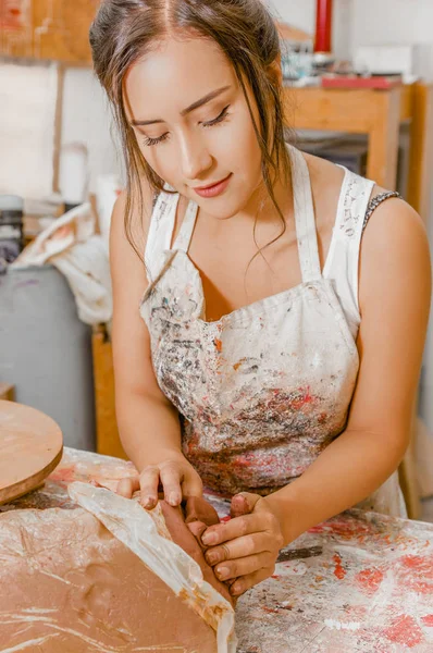 Close up van vrouw keramist bezig met beeldhouwkunst op houten tafel in werkplaats — Stockfoto