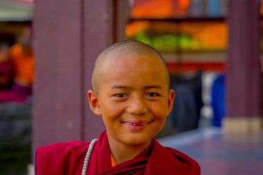 Pokhara, Nepal - 06 Ekim 2017: Tashi mülteci yerleşim Pokhara, Nepal, öğle yemeği sırasında kameraya gülümseyen Budist keşiş çocuk portresi