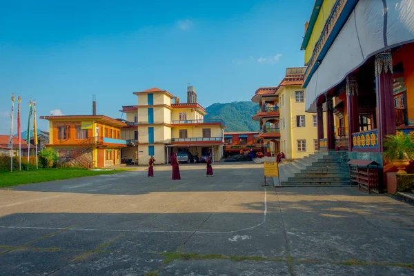 POKHARA, NEPAL - 06 DE OCTUBRE DE 2017: Monjes budistas no identificados adolescentes disfrutando del tiempo libre en un patio al aire libre en un hermoso día en el asentamiento de refugiados Tashi en Pokhara, Nepal — Foto de Stock