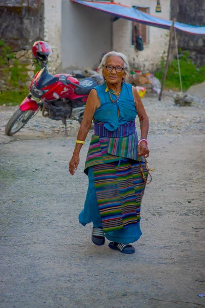Pokhara, nepal - 06. Oktober 2017: Nahaufnahme einer alten tibetischen Frau, die auf der Straße im Dorf Tashi ling läuft. tashi ling ist eines der tibetischen Flüchtlingslager in Nepal — Stockfoto