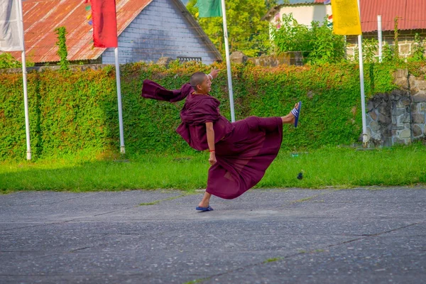 POKHARA, NEPAL - 06 DE OCTUBRE DE 2017: Niño monje budista no identificado caminando al aire libre en el asentamiento de refugiados Tashi en Pokhara, Nepal — Foto de Stock