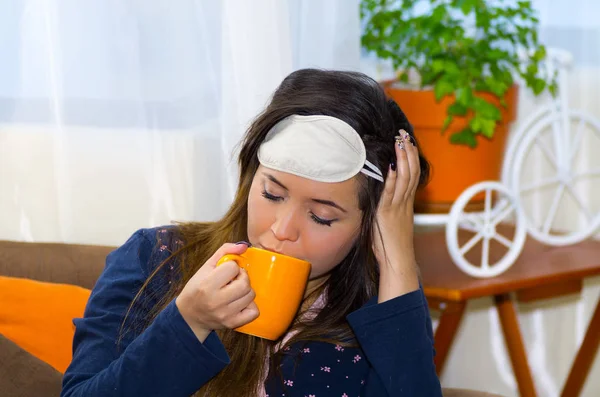 Mujer borracha bebiendo agua en una taza naranja, después de una fiesta, concepto de resaca — Foto de Stock