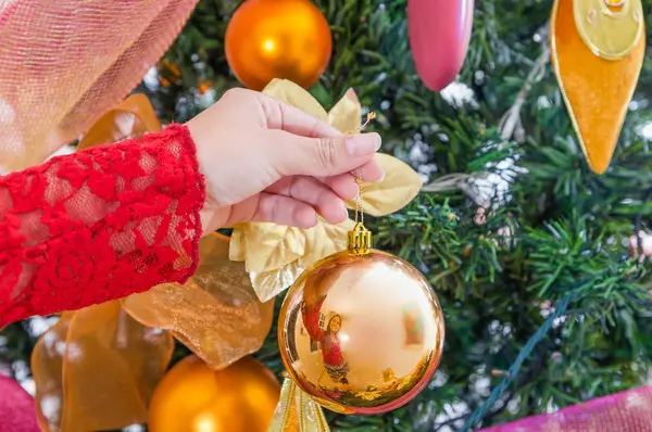 Bir Noel ağacı, neşeli Noel ve mutlu yeni yıl kavramı dekorasyon bir Noel top tutan kadın el yakın çekim — Stok fotoğraf