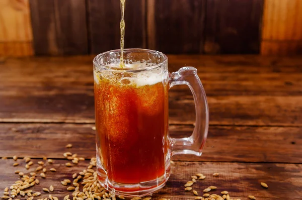 Wewnątrz widok szklankę piwa z pszenicy w bazie na drewnianym stole na ciemny pub — Zdjęcie stockowe