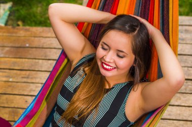 Genç güzel kadın Bahçe, arka plan bulanık bir hamakta rahatlatıcı görünümünü yukarıda